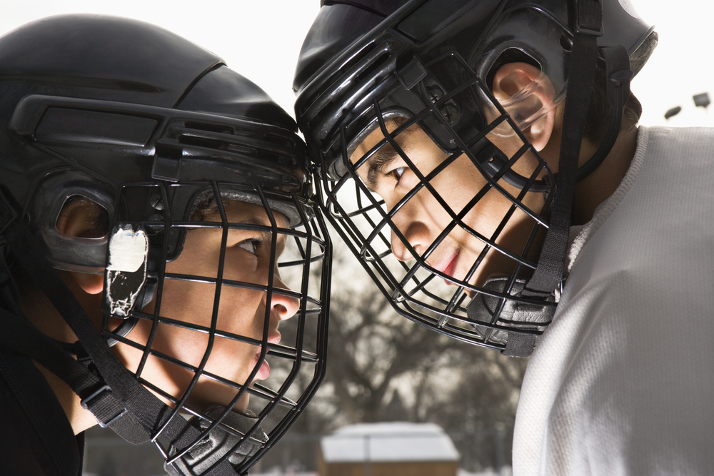 Two ice hockey players in uniform facing off trying to intimidate eachother.